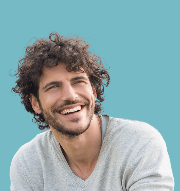 A smiling man with curly hair looking away from the camera against a teal background.